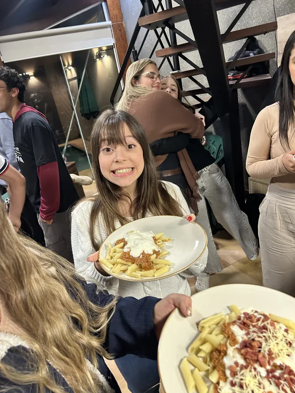 Uma participante mostrando o prato em uma refeição compartilhada.